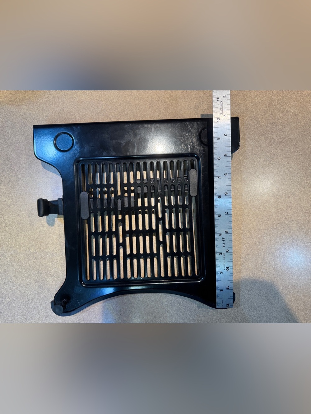 Black metal laptop VESA mounting tray with ventilation grille
